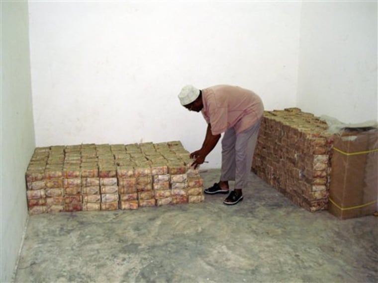 A Somali official of the central bank in Mogadishu, Somalia, arranges Somali bank notes at the bank, on March 17. Somali politicians are returning from Arab nations with briefcases of cash, and a new report and an Associated Press investigation found that $80 million given to government officials that could have been used to fight terrorism, piracy or hunger is missing. 
